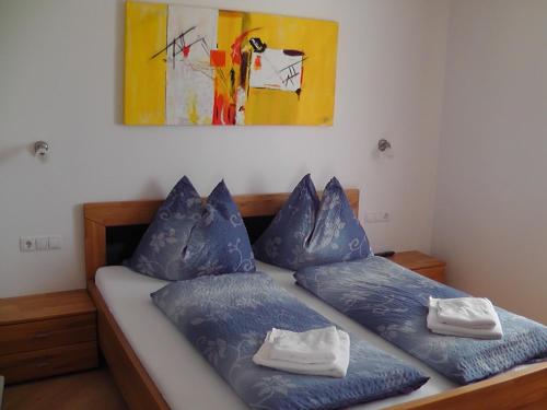 弗拉绍耶格尔公寓的一间卧室配有一张带蓝色枕头的床和一幅画