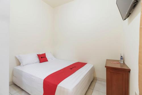 雅加达RedDoorz @ Tanjung Duren的卧室配有一张带红色毯子的白色床