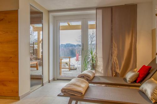 乌尔里希斯贝格Gästehaus "In da Wiesn"的客房设有窗户和带枕头的长凳。