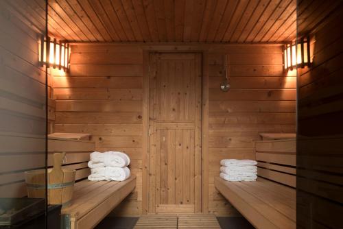 赫伦塔尔斯Hotel Karmel的一间带木墙和毛巾的桑拿浴室