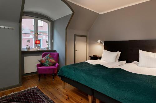 斯德哥尔摩胜利公寓 的一间卧室配有一张床和一张紫色椅子