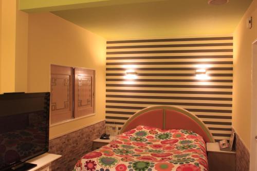 MetabaruHotel Miami (Adult Only)的一间卧室配有一张床和条纹墙