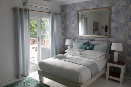 东伦敦Blue's Guest House - East London Bonza Bay的一间卧室配有一张大床和镜子