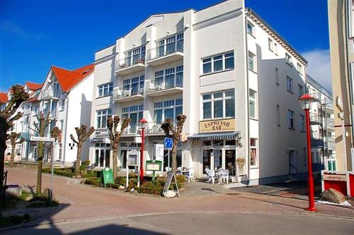 宾茨Haus Jahreszeiten Appartement Meeresrauscher by Unsere Urlaubszeit的街道拐角处的白色大建筑