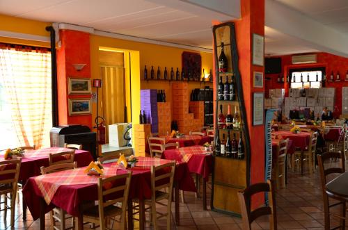 帕拉佐罗德罗斯泰尔拉迪安塞尔米农家乐的餐厅配有桌椅和红色桌布