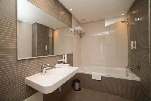 拉巴特拉巴特总站奥诺莫酒店的浴室配有盥洗盆和浴缸。
