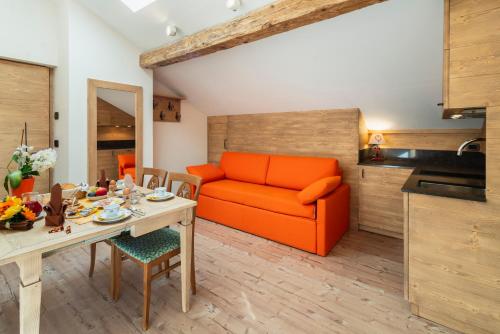 萨帕达豪斯麦克拉酒店的客厅配有橙色沙发和桌子