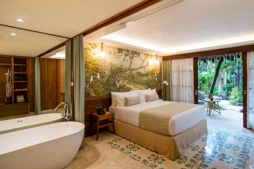乌布Adiwana Monkey Forest的一间卧室配有一张床、一个浴缸和一个浴缸