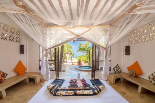 马特姆维Zoi Boutique Hotel Zanzibar ex Sunshine Hotel的一间卧室设有一张床和一个大窗户