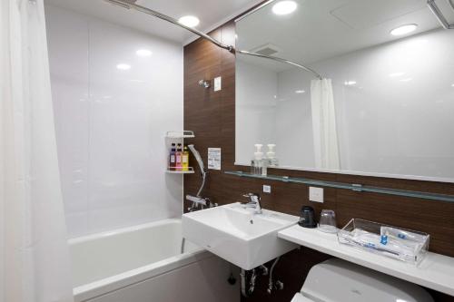 高知舒适高知酒店的一间带水槽、浴缸和镜子的浴室
