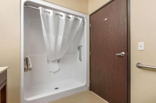 锡达福尔斯锡达福尔斯康福特套房酒店的浴室内带窗帘的白色淋浴