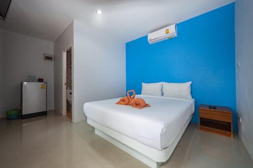 湄南海滩湄南别墅酒店的卧室配有一张白色的床,上面有一只动物填充物