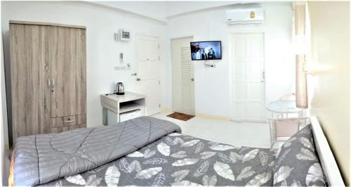 合艾Baankanjana的一间卧室配有一张床,墙上配有电视
