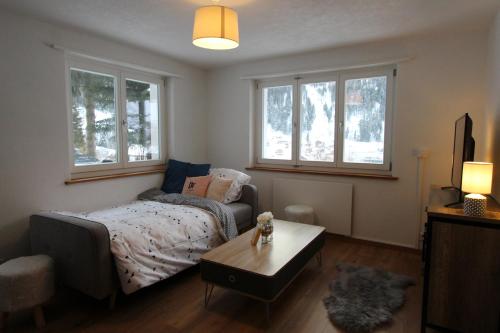 库尔瓦尔登Haus Siegfried的卧室配有床、桌子和窗户。