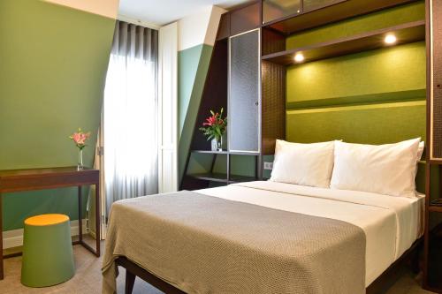 里斯本My Story Hotel Augusta的一间卧室设有一张大床和绿色的墙壁