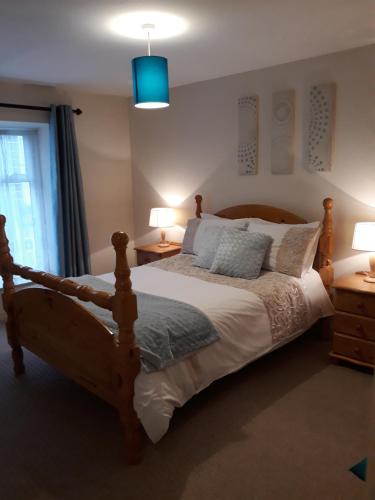 斯温福德Swinford Bridge Street Apartment的一间卧室配有一张床、两盏灯和一个窗户。