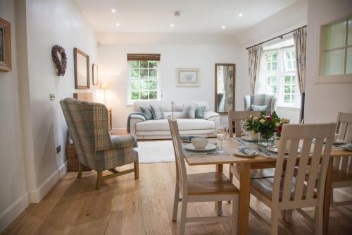 邓布兰The Gardener's Cottage的客厅配有桌椅和沙发