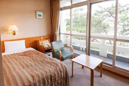 Ichikikushikino串木野艾克西亚酒店的酒店的客房 - 带一张床、椅子和窗户