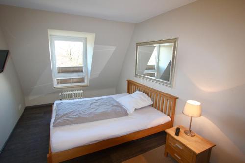 黑明根Appartement Moulineaux的一间小卧室,配有床和2个窗户