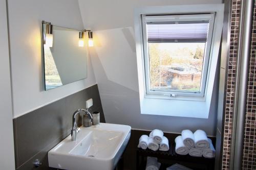 黑明根Appartement Moulineaux的一间带水槽和镜子的浴室以及窗户。