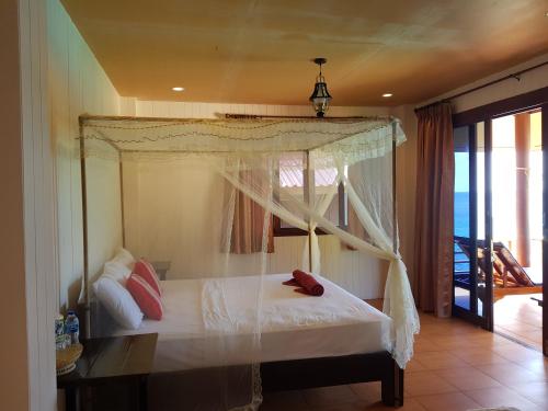 涛岛奥洛伊克大山度假村的卧室设有天蓬床和阳台