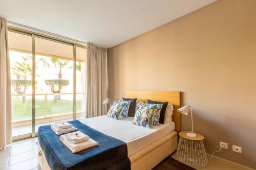 阿尔布费拉Apartments Maria - Salgados 10A0D的一间卧室设有一张床和一个大窗户