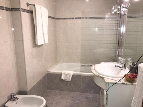 莱昂希格罗二十一公寓式酒店的带浴缸、盥洗盆和卫生间的浴室