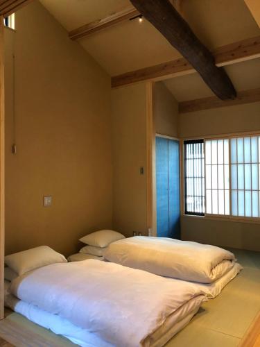 京都Komatsu Residences的带2扇窗户的客房内的2张床