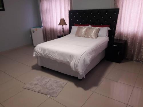 鲸湾港杰西玛住宿加早餐旅馆的卧室配有一张带白色床单和枕头的大床。