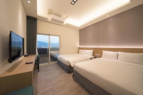 台东如意行馆的酒店客房设有两张床和一台平面电视。