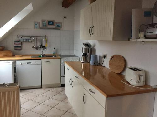 ZarrentinSchaalseeblick的厨房配有白色橱柜和木制台面