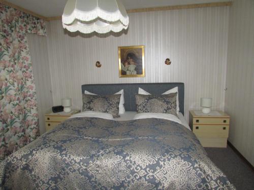 伊姆斯特Ferienhaus Tschenett的一间卧室设有一张大床和两个床头柜