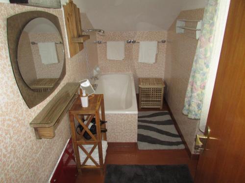 伊姆斯特Ferienhaus Tschenett的带浴缸、水槽和镜子的浴室