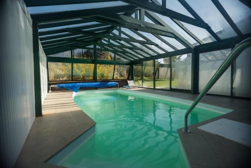 Mazingarbe安妮特之家住宿加早餐旅馆的一座带玻璃天花板的别墅内的游泳池