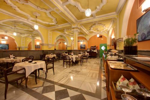 格拉纳达英拉特拉酒店的一间在房间内配有桌椅的餐厅