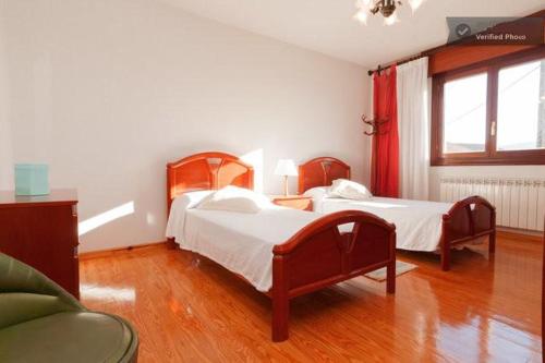 佩德勒纳Casa Bahía Santander的一间带两张床和一张沙发的卧室