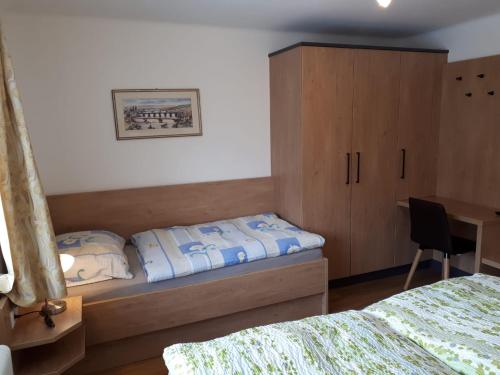 圣迈克尔隆高Ferienhaus Reinfrank的一间卧室配有一张床、一个橱柜和一张书桌