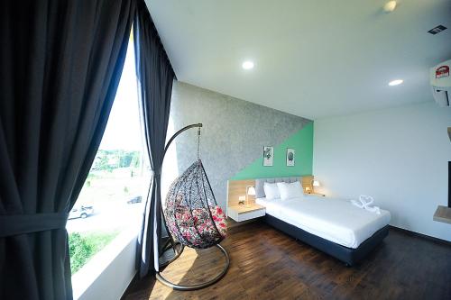 麻坡MYe Hotel的卧室配有一张床,窗户旁设有秋千。