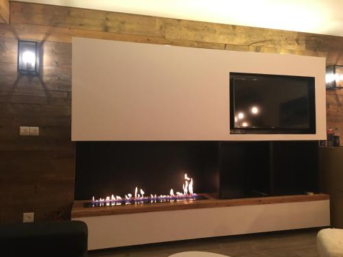 韦尔比耶Verbier Medran + Private Sauna的客厅设有壁炉,上面配有电视