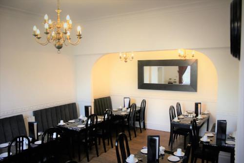 坎特伯雷坎特伯雷酒店的一间带桌椅和镜子的用餐室
