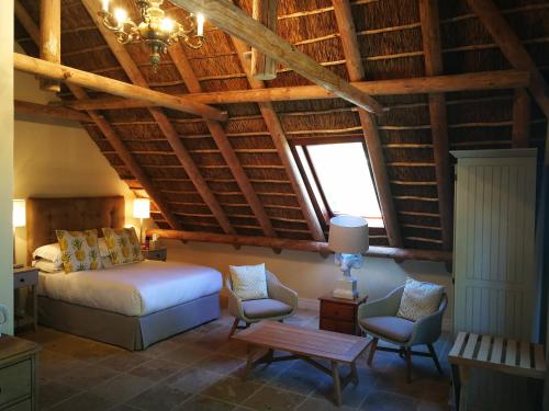 斯泰伦博斯Gemoedsrus Farm的一间卧室配有一张床、两把椅子和一张桌子