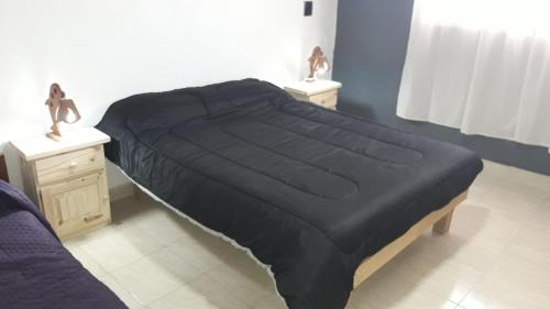 克拉罗梅科Lo de Marito的卧室内的一张带黑色棉被的床