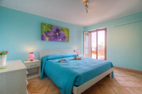 福尔米亚Appartamento a pochi passi dal mare的蓝色卧室,配有一张带蓝色毯子的床