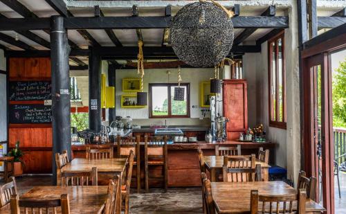 萨兰托Coffee Tree Boutique Hostel的一间带木桌椅的餐厅和一间酒吧