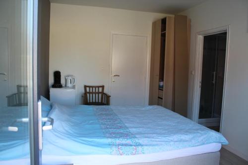 迪尔森-斯托科姆Logie Rotem的一间卧室配有一张带蓝色毯子的床