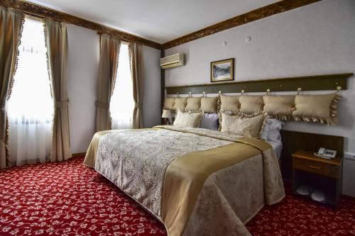 伯萨萨弗兰酒店的一间卧室配有一张大床和红地毯