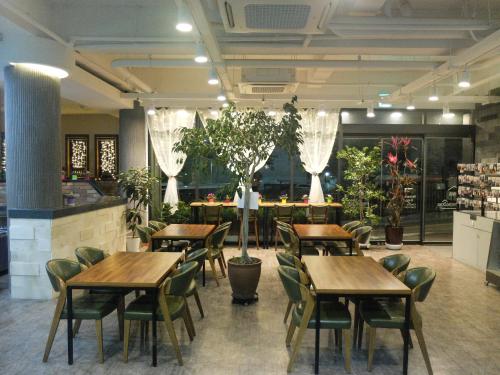 首尔爱华明洞酒店的餐厅设有木桌和椅子,种有植物