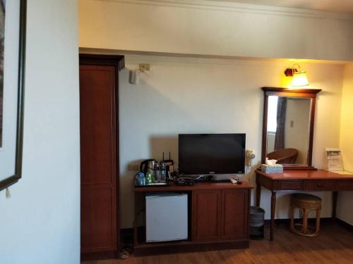 恒春古城垦丁小天地度假旅店的一间配有电视和书桌的房间