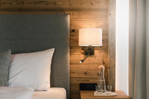 费尔兹姆斯meiZeit Lodge的一间卧室配有一张床和一张桌子上的台灯