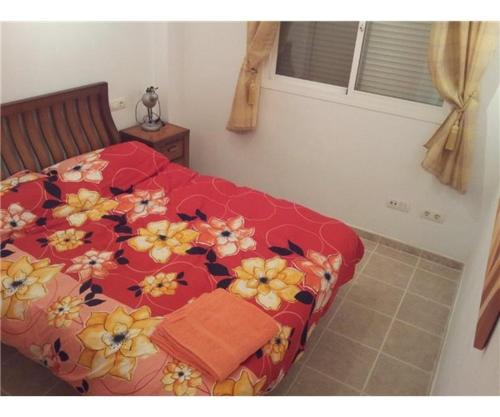 卡萨雷斯Penthouse, Casares del Sol, Malaga的一间卧室配有红色的床,床上有鲜花